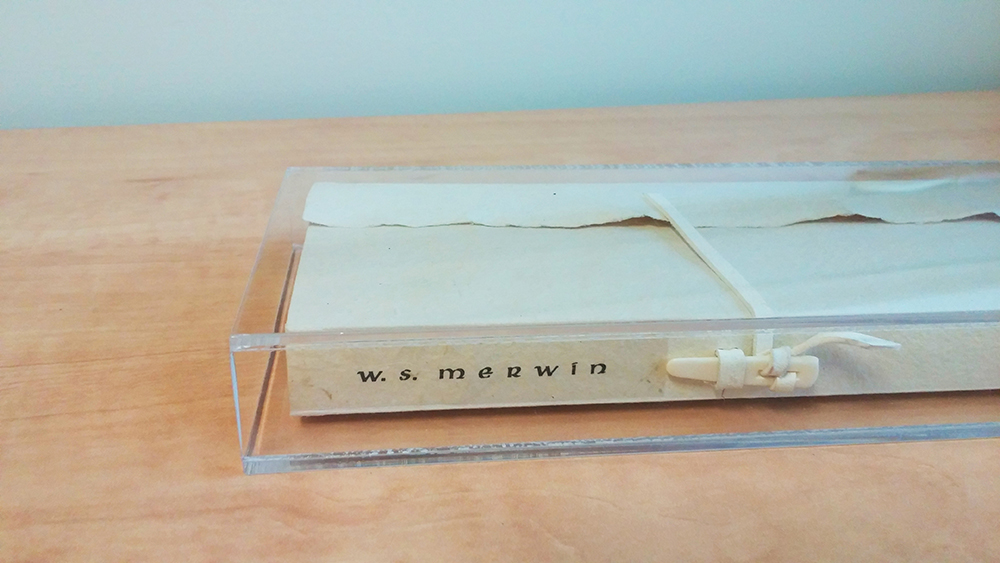 Set inside a white paper tri-fold cover, this book is fitted within a clear, rectangular lacquer box. The spine of the cover states "W.S. Merwin" and "Ninja Press".